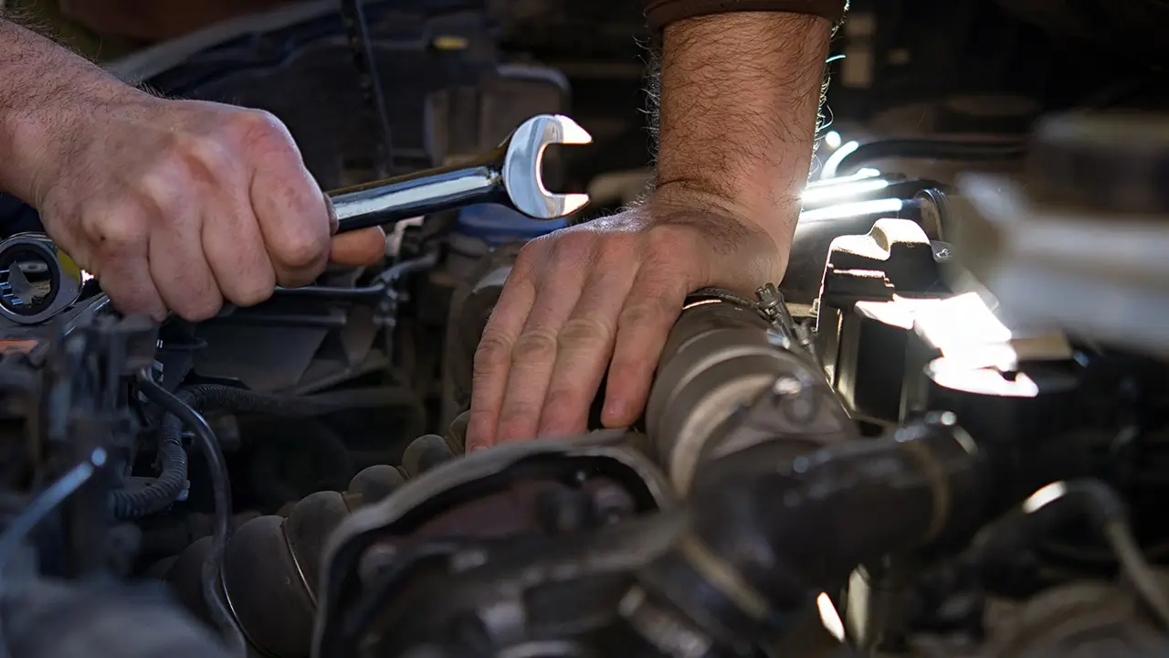 Kfz-Mechaniker arbeitet an der Motorhaube